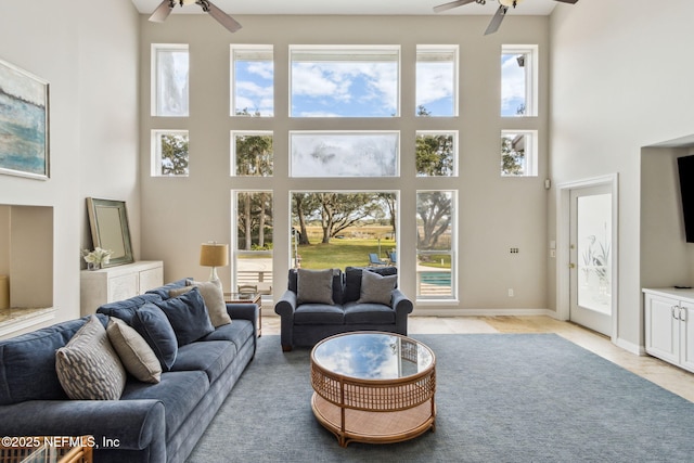 living room featuring a towering ceiling and ceiling fan