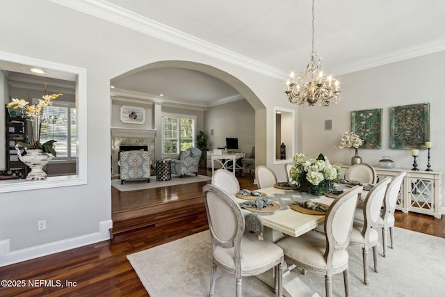 dining space featuring crown molding, an inviting chandelier, and dark hardwood / wood-style flooring