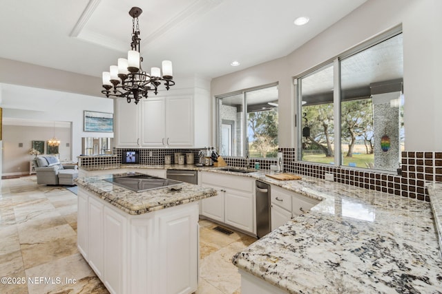 kitchen with an inviting chandelier, white cabinetry, and light stone counters