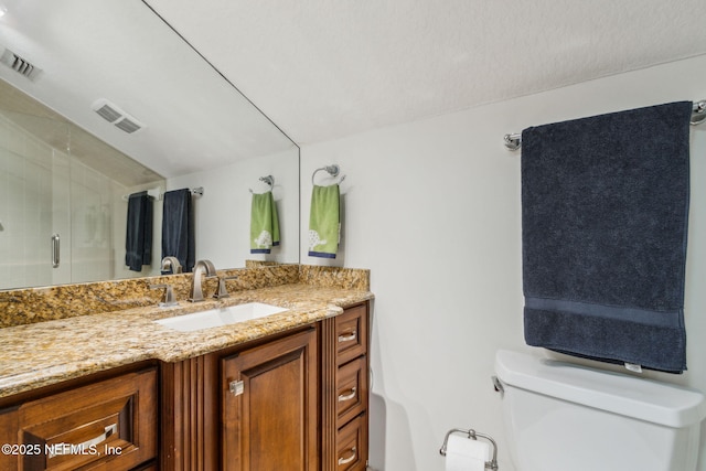 bathroom with vanity, toilet, and an enclosed shower