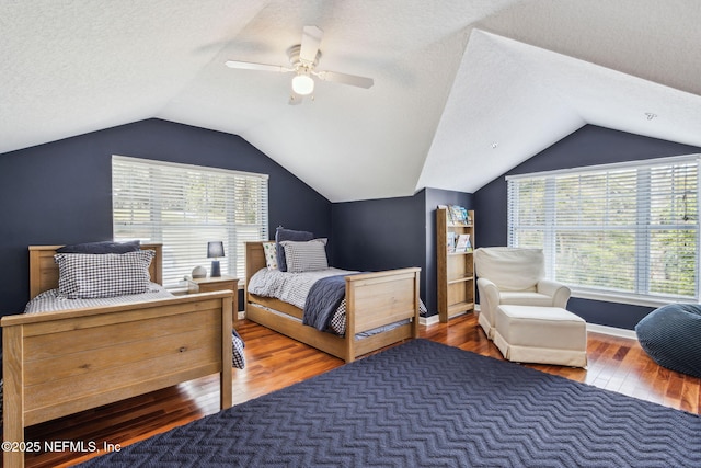 bedroom with ceiling fan, lofted ceiling, dark hardwood / wood-style floors, and a textured ceiling