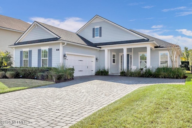 view of front facade featuring a porch, a garage, and a front yard