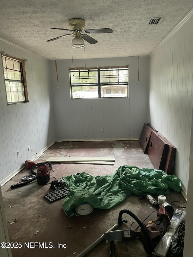 unfurnished room featuring ceiling fan, ornamental molding, and a textured ceiling