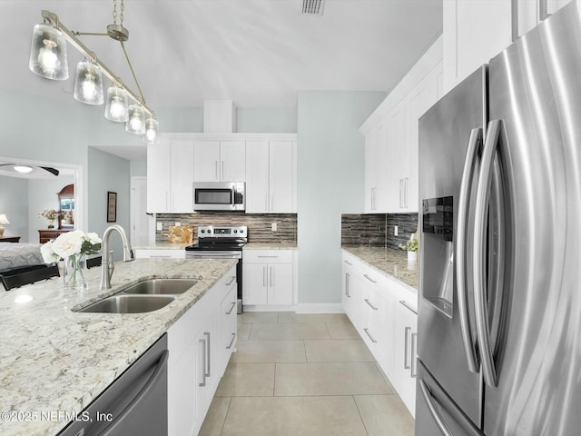 kitchen with white cabinetry, sink, decorative light fixtures, and appliances with stainless steel finishes