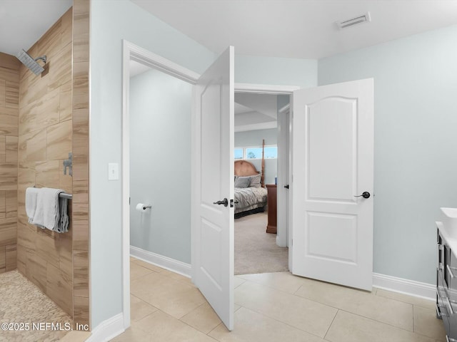 bathroom with tiled shower, tile patterned floors, and vanity