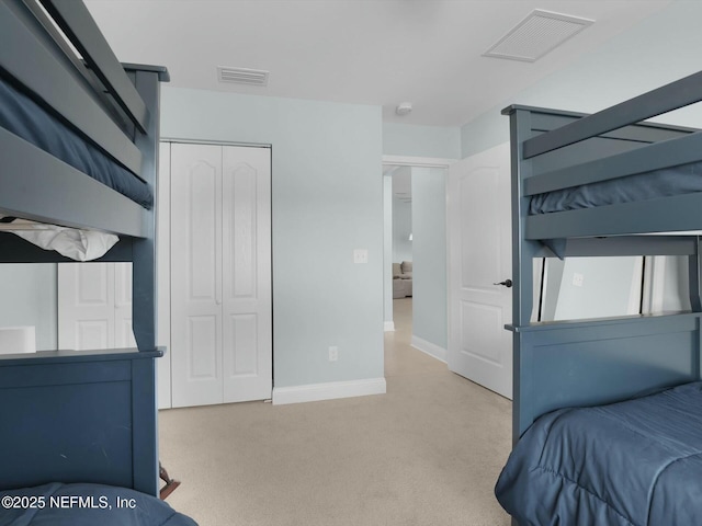 bedroom featuring light colored carpet and a closet