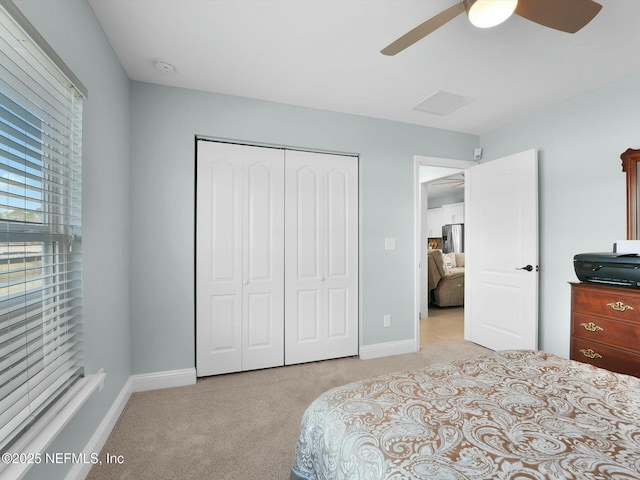 carpeted bedroom featuring stainless steel fridge, ceiling fan, and a closet