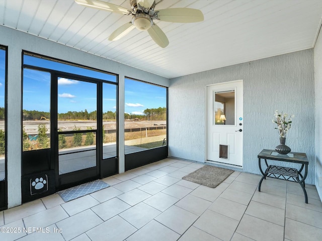 unfurnished sunroom with ceiling fan