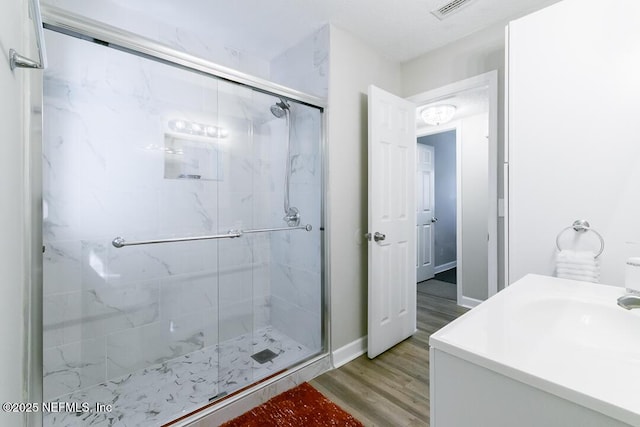 bathroom with an enclosed shower and wood-type flooring