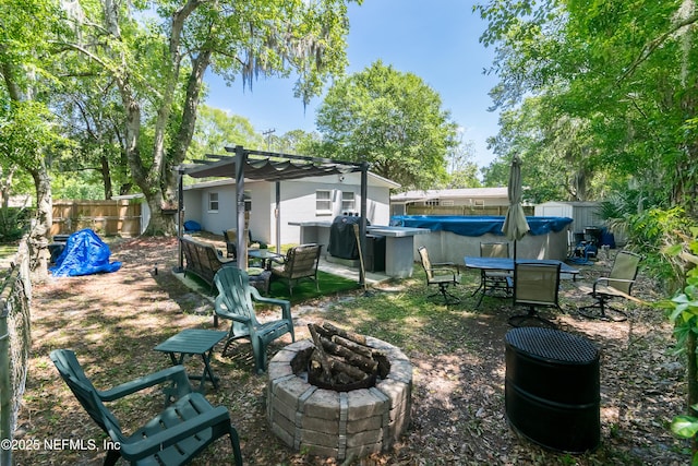 view of yard featuring a pergola, a covered pool, and a fire pit