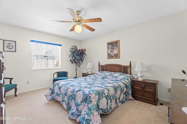 bedroom with ceiling fan, light carpet, and a textured ceiling