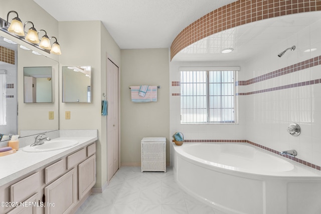 bathroom with vanity, a bath, and a textured ceiling