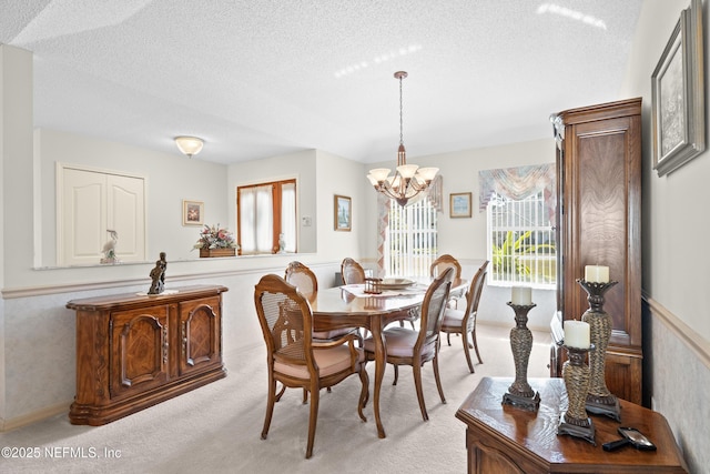 carpeted dining room with a textured ceiling and an inviting chandelier