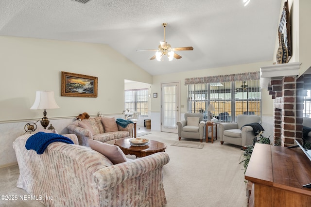 carpeted living room featuring ceiling fan, vaulted ceiling, and a textured ceiling