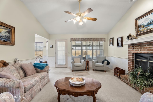 living room with ceiling fan, high vaulted ceiling, light carpet, and a fireplace