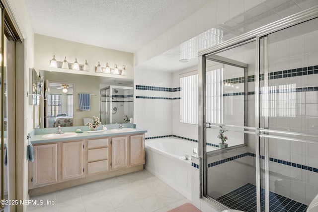 bathroom featuring vanity, independent shower and bath, a textured ceiling, and a wealth of natural light