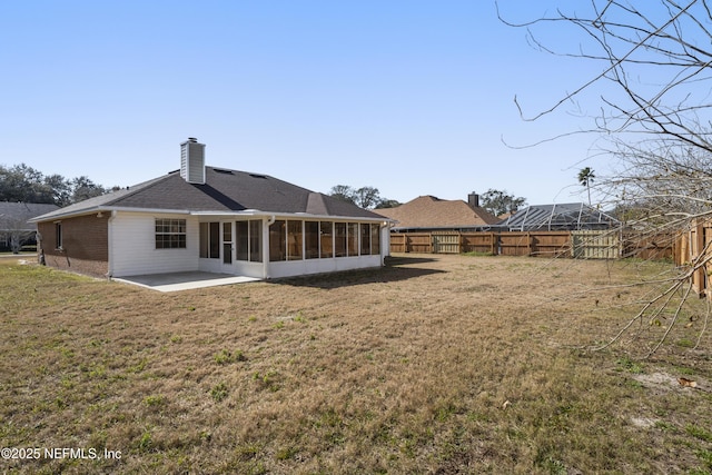 back of house with a sunroom, a yard, and a patio area