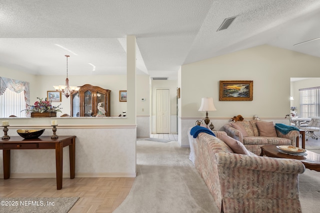 living room featuring light parquet floors, lofted ceiling, a notable chandelier, and a textured ceiling