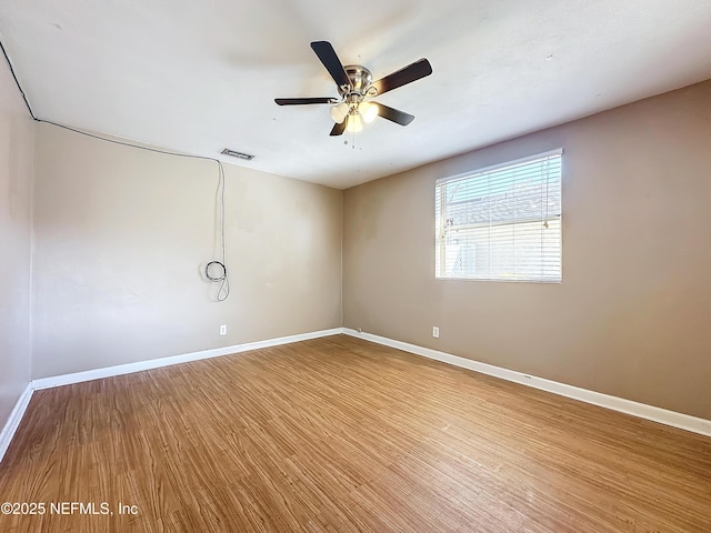 empty room with hardwood / wood-style flooring and ceiling fan