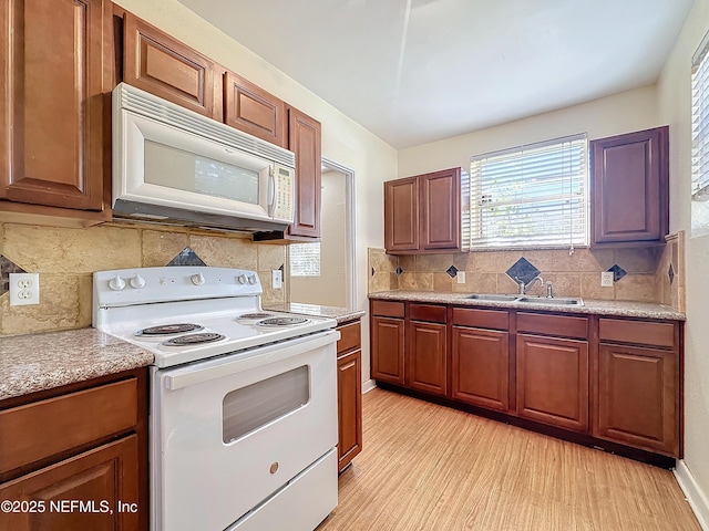 kitchen featuring white appliances, light hardwood / wood-style floors, sink, and decorative backsplash