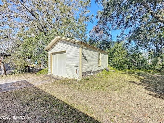 view of outbuilding featuring a garage and a lawn