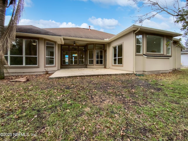 rear view of house with ceiling fan and a patio area