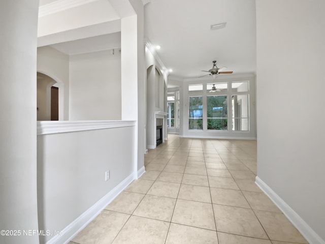 corridor featuring ornamental molding and light tile patterned floors