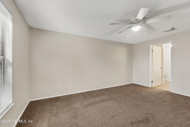 carpeted spare room featuring a textured ceiling and ceiling fan