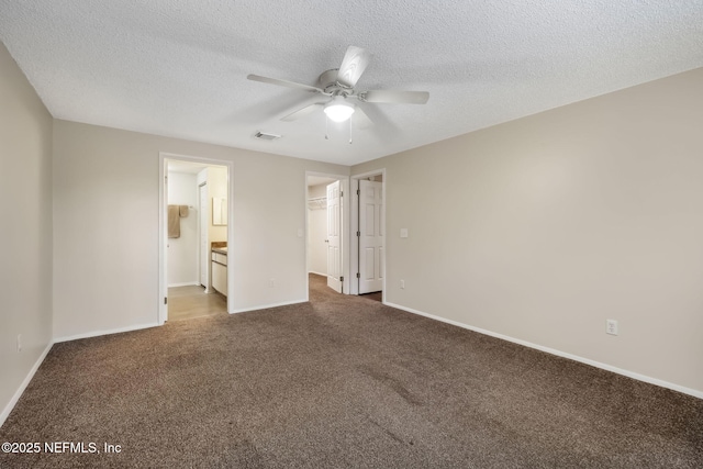 unfurnished bedroom featuring dark colored carpet, ensuite bath, a textured ceiling, a closet, and ceiling fan