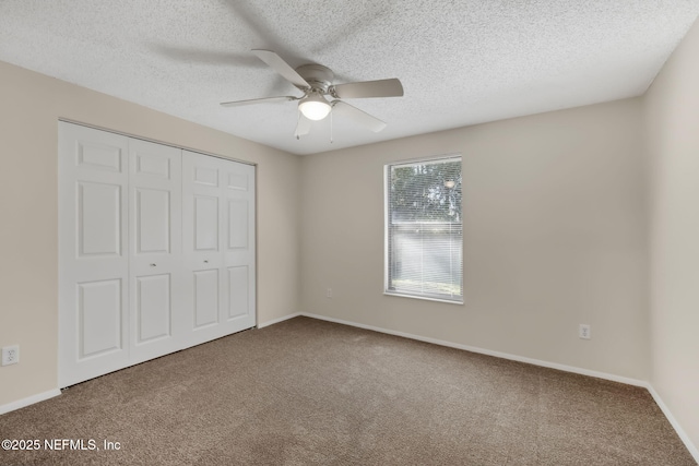 unfurnished bedroom featuring a textured ceiling, a closet, ceiling fan, and carpet flooring