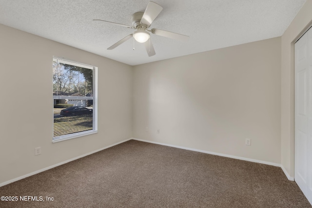 carpeted empty room with ceiling fan and a textured ceiling