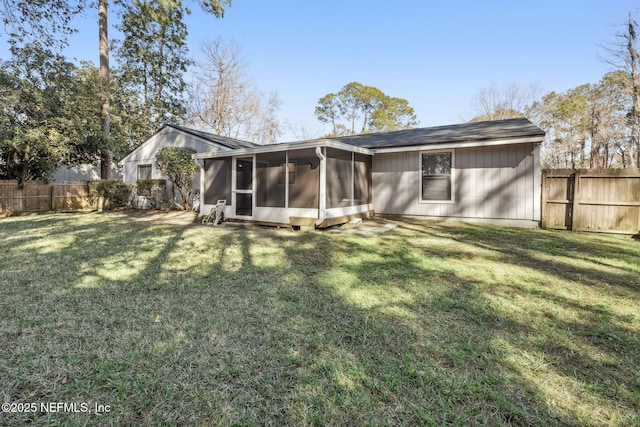 back of property with a yard and a sunroom