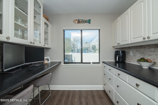 kitchen featuring tasteful backsplash, dark hardwood / wood-style floors, white cabinets, and a textured ceiling