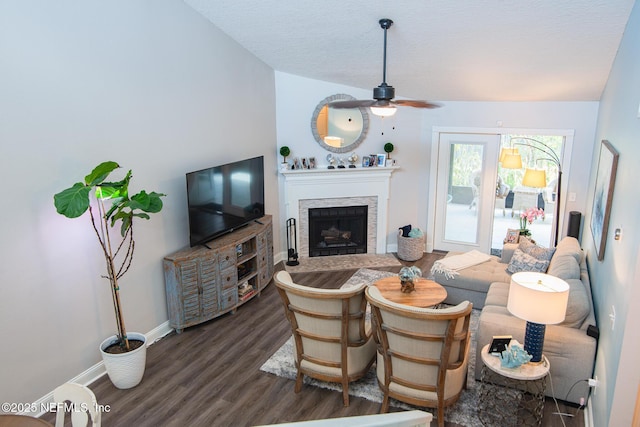 living room with ceiling fan, dark hardwood / wood-style flooring, and a textured ceiling