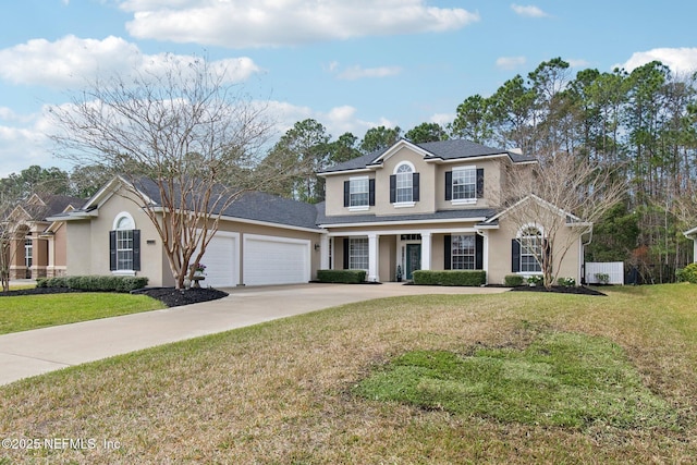 view of front facade with a garage, stucco siding, concrete driveway, and a front yard