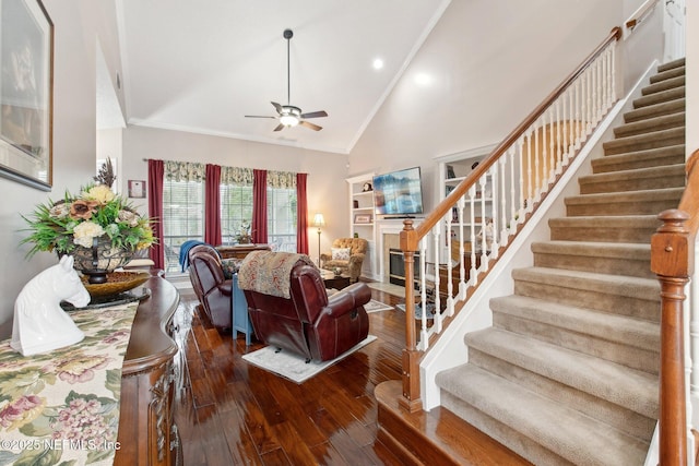 living room featuring high vaulted ceiling, hardwood / wood-style flooring, a ceiling fan, stairway, and crown molding