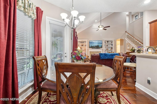 dining space with arched walkways, lofted ceiling, wood finished floors, baseboards, and ceiling fan with notable chandelier