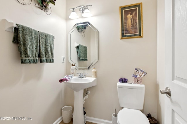 bathroom with toilet and baseboards