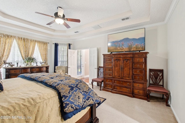 bedroom featuring a raised ceiling, visible vents, light carpet, and a textured ceiling