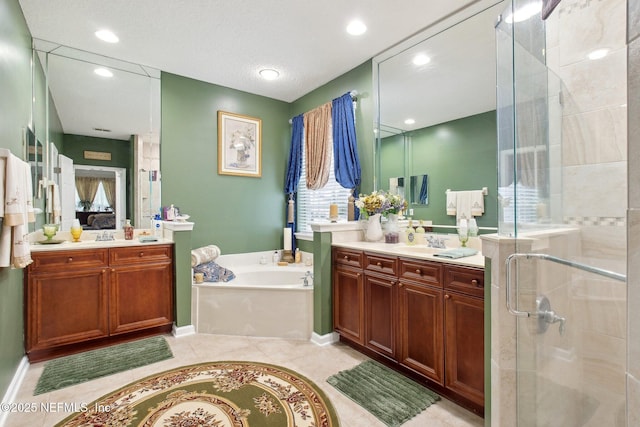 full bath with a garden tub, tile patterned flooring, a sink, two vanities, and a stall shower