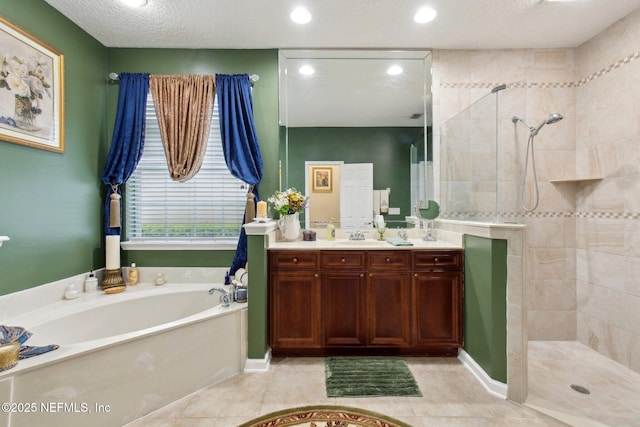 bathroom with double vanity, a sink, a walk in shower, tile patterned flooring, and a bath