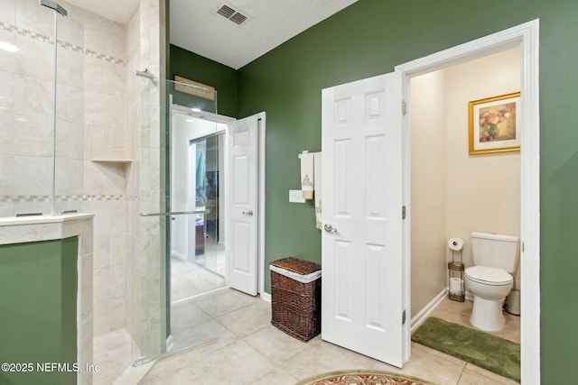 full bathroom with a walk in shower, toilet, visible vents, baseboards, and tile patterned floors