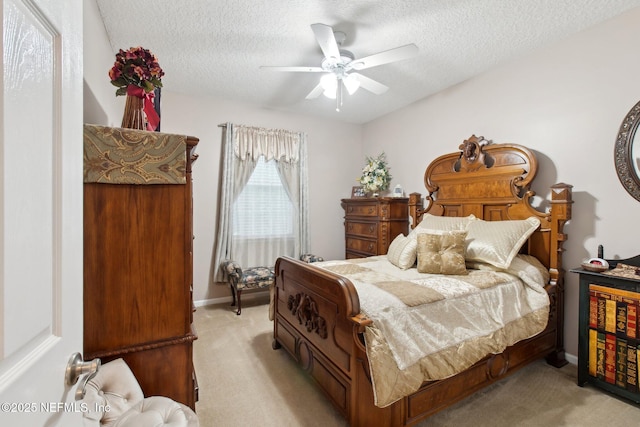 bedroom with light carpet, a textured ceiling, a ceiling fan, and baseboards