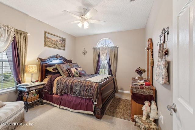 bedroom with a ceiling fan, carpet, and a textured ceiling