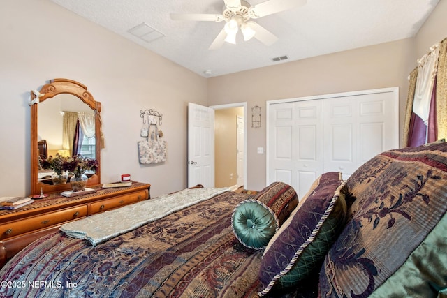 bedroom with a ceiling fan, a textured ceiling, visible vents, and a closet