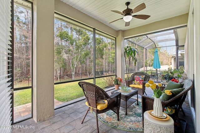 sunroom / solarium with a ceiling fan