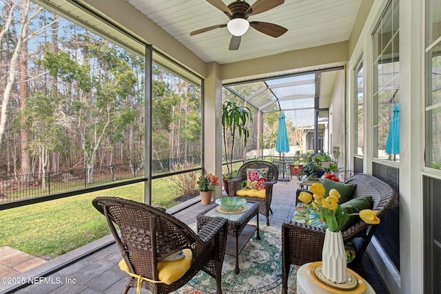 sunroom featuring ceiling fan and a wealth of natural light