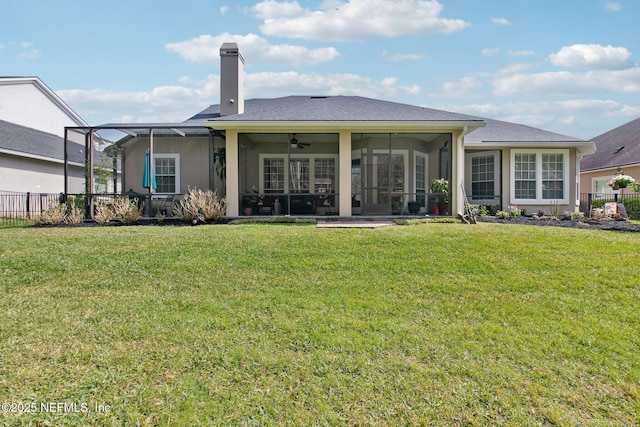 rear view of property featuring stucco siding, a chimney, fence, and a yard