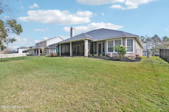 back of property featuring a sunroom, a fenced backyard, a chimney, and a lawn