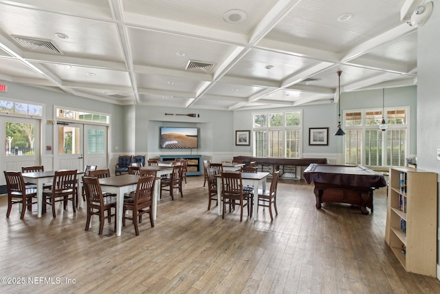 dining space with a wainscoted wall, visible vents, coffered ceiling, and hardwood / wood-style floors